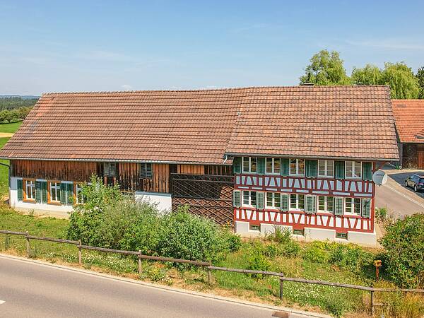 Traditionelles Wohnhaus mit historischer Remise und umgebender Kulturlandsc...